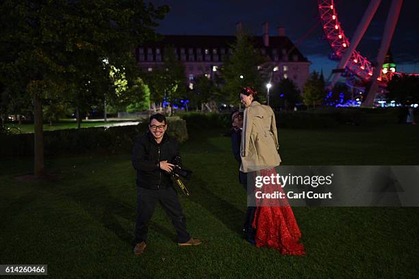 Echo Li and her fiance Charles Qian, are instructed on how to pose by photographer Dominic Wu during a pre-wedding photography shoot next the London...