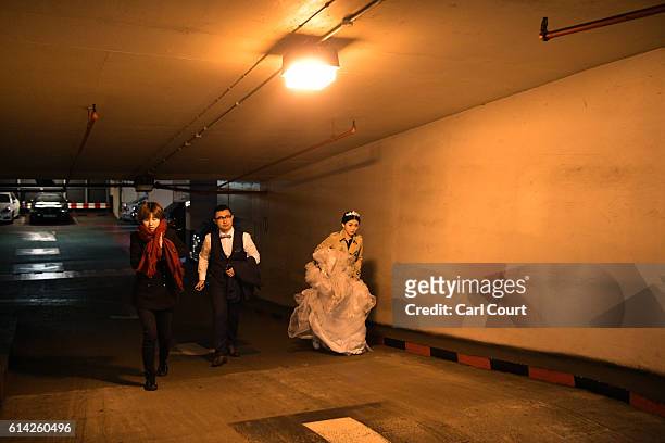 Dress assistant Susan Su walks with Echo Li and her fiance Charles Qian as they make their way through an underground carpark to start their...