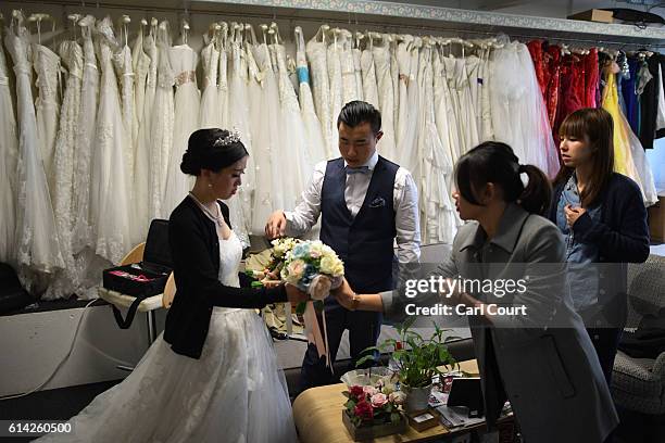 Echo Li and her fiance Charles Qian , both from Shenzhen in China, choose bouquets as they prepare to have pre-wedding photographs taken next to...