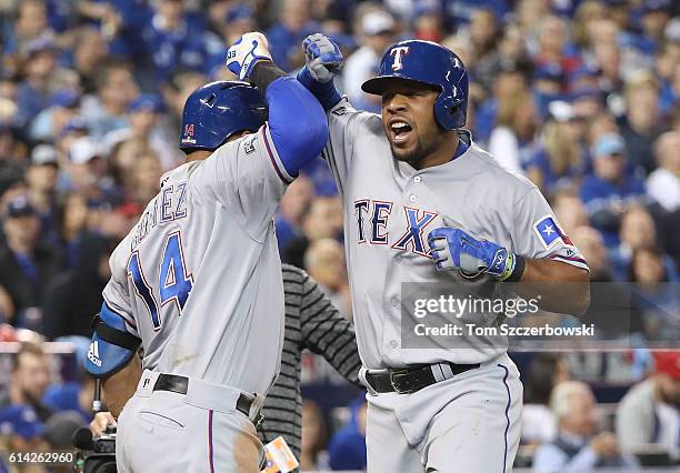 Elvis Andrus of the Texas Rangers is congratulated by Carlos Gomez after hitting a solo home run in the third inning during MLB game action against...