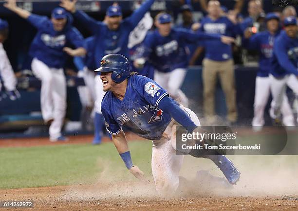 Josh Donaldson of the Toronto Blue Jays celebrates after scoring the game-winning run in the tenth inning during MLB game action against the Texas...