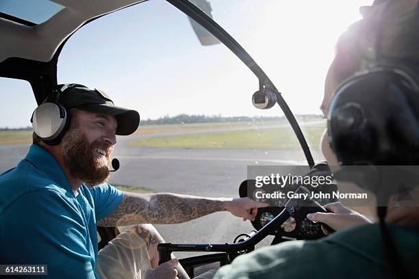 instructor teaching woman in helicopter cockpit - helicopter pilot stock pictures, royalty-free photos & images