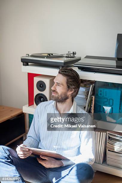 portrait of bearded man at home with hifi equipment - personal stereo stockfoto's en -beelden