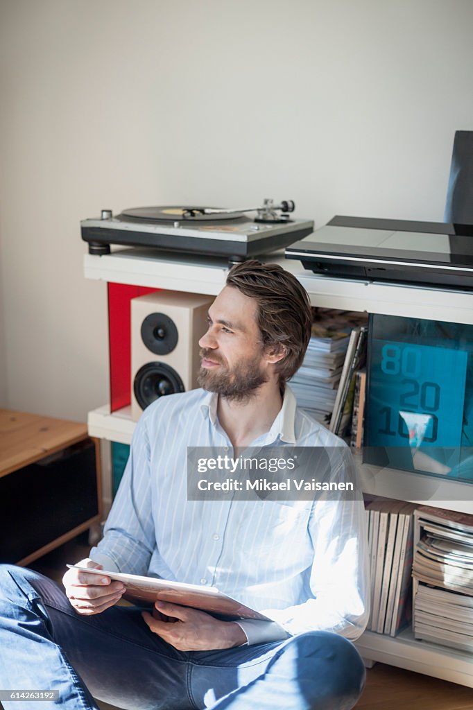 Portrait of bearded man at home with hifi equipment