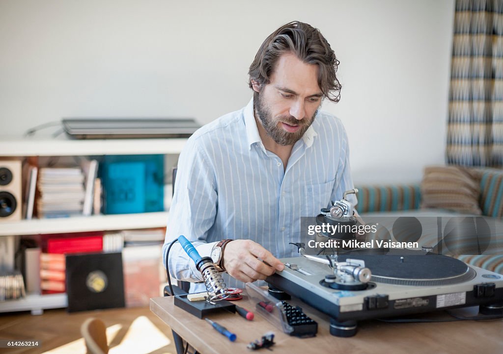 Portrait of bearded man at home with hifi equipment