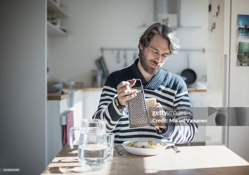 Portrait of bearded man eating at home