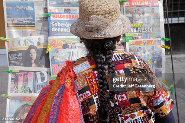 Woman reading a newspaper at a newsstand in Avenida Miguel Grau.