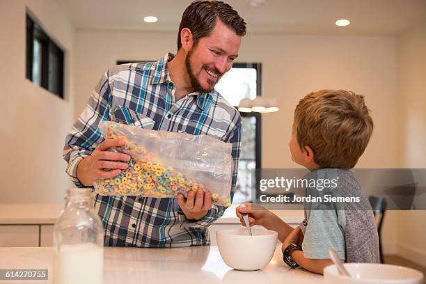 a dad pouring his kids cereal. - mt cook fotografías e imágenes de stock