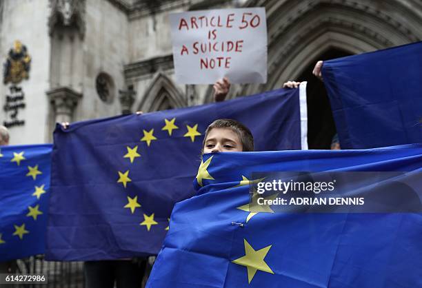 Pro-European Union supporters stand at the entrance to The Royal Courts of Justice, Britain's High Court, in London on October 13 during a protest...