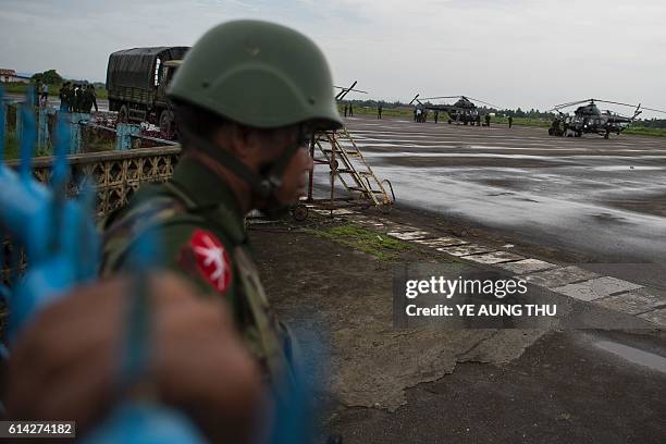 Soldier stands guard, as Myanmar air force helicopter arrive at Sittwe airport in Sittwe capital of Rakhine State on October 13 with troops pouring...