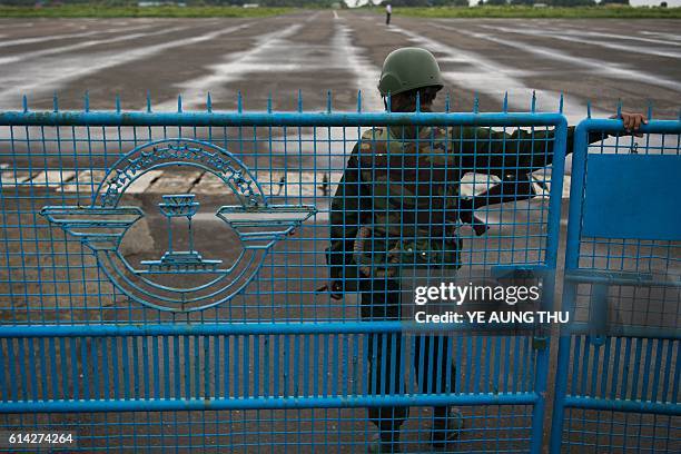 Soldier stands guard, as Myanmar air force helicopter arrive at Sittwe airport in Sittwe capital of Rakhine State on October 13 with troops pouring...