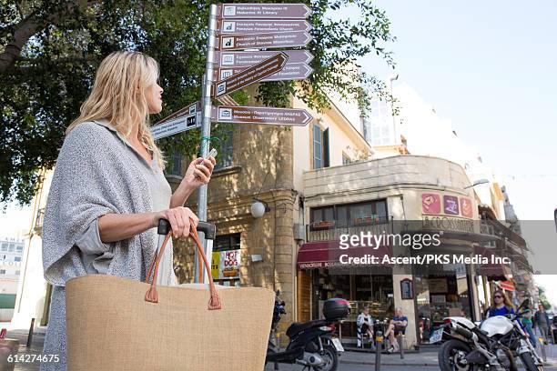 female traveller pauses, looks up to signpost - cyprus stockfoto's en -beelden