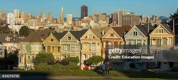 San Francisco California Painted Ladies Victorian homes and city in background at Alamo Square at Hayes Street and Steiner Street .