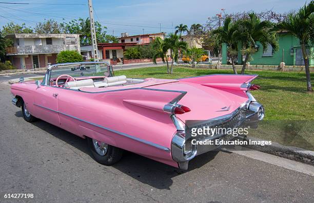 Varadero Beach Cuba famous pink 1959 big pink Cadilllac with fins and abstracts on street.