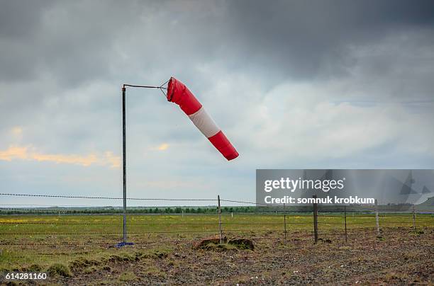 wind sock in field under cloudy sky - windsock stock pictures, royalty-free photos & images