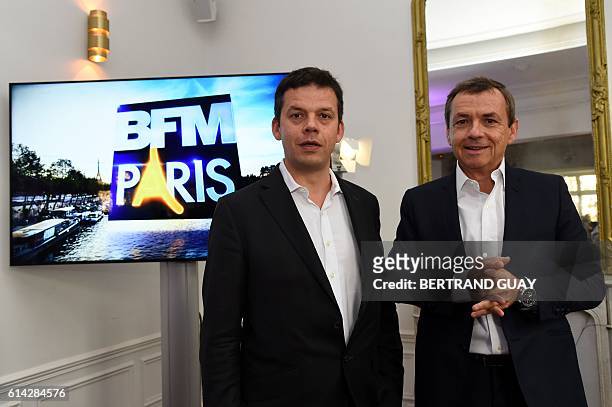 President of the NextRadioTV group and CEO of SFR group in charge of Media activities Alain Weill stands next to editorial director of BFM Paris...