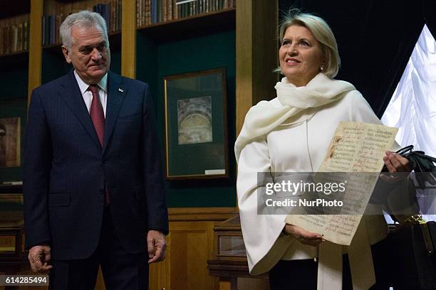 Serbian President Nikolic and his wife Dragica Nikolic holds a copy the page from Miroslav's Gospel during visit the National Library of Russia in St...