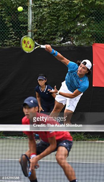 Akira Santillan of Japan serves during the men's doubles first round match against Tomas Berdych and Radek Stepanek of the Czech Republic on day two...