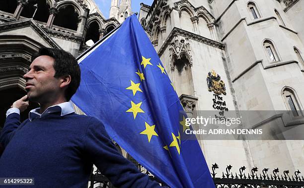 Pro-European Union supporter Phil Jones holds an EU flag outside the entrance to The Royal Courts of Justice, Britain's High Court, in London on...