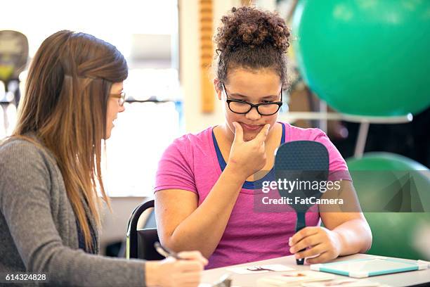 young female in a speech therapy exercise - speech therapy imagens e fotografias de stock