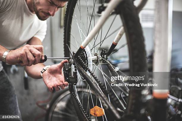 mechanic repairing bicycle transmission - bicycle tire stockfoto's en -beelden