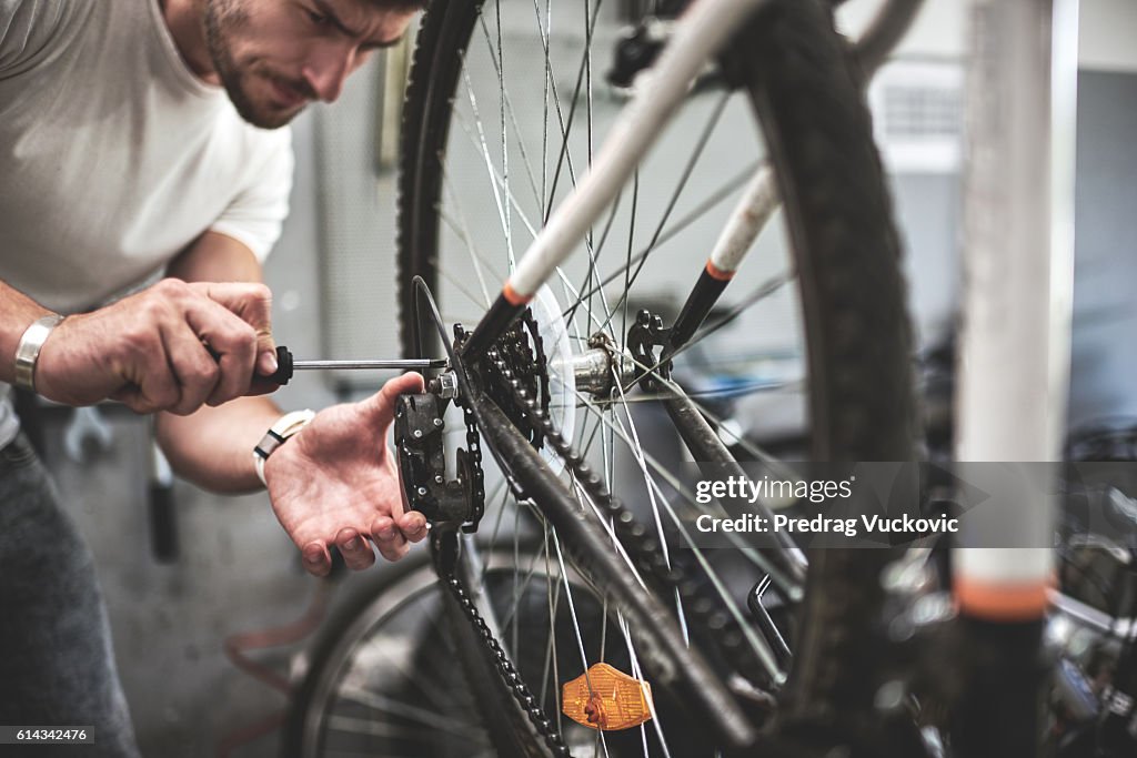 Mechanic repairing bicycle transmission