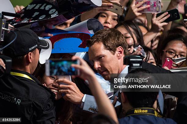 British actor Benedict Cumberbatch poses for a selfie with a fan as he arrives for a red carpet event to promote his latest movie, Marvel's "Doctor...