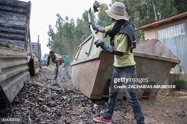 Workers clean up destroyed beer bottles that were on trucks belonging to Meta brewing of Ethiopia, owned by the British firm Diageo, in Sebeta on...