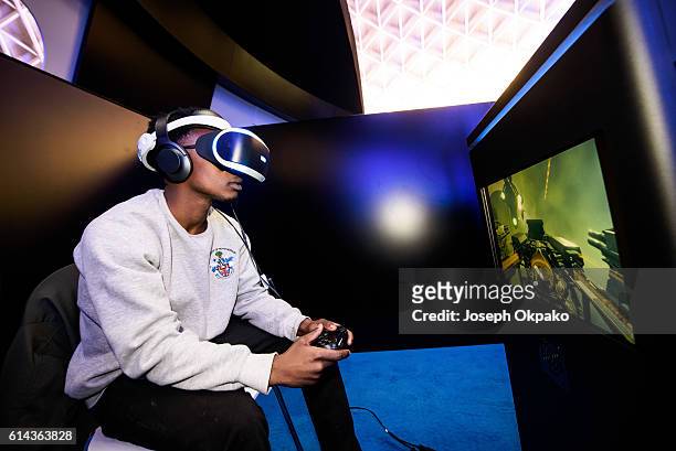 Man wears a PlayStation VR headset developed by Sony Interactive Entertainment LLC. To experience a 360-degree game in virtual reality, during a...