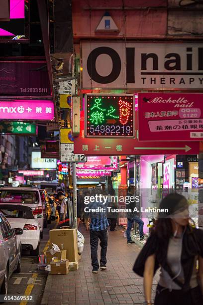 people walking at a sidewalk at the hennessy road in causeway bay, hong kong at night. - hennessy road photos et images de collection