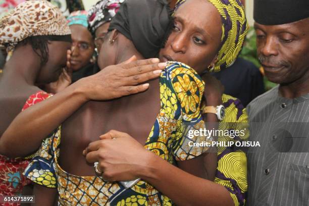 Nigerian Vice President Yemi Osinbajo looks on while his wife Dolapo comforts one of the 21 freed Chibok girls freed today from Boko Haram, at his...