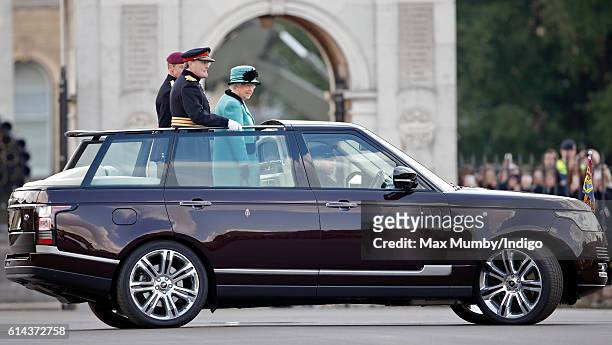Queen Elizabeth II, Colonel-in-Chief of the Corps of Royal Engineers stands in the State Review Range Rover to inspect a parade of troops and...