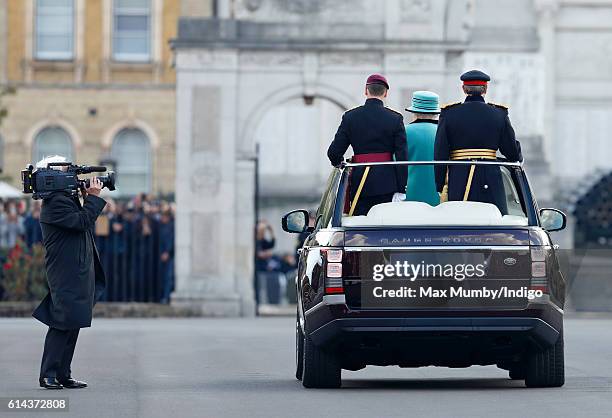 Queen Elizabeth II, Colonel-in-Chief of the Corps of Royal Engineers, stands in the State Review Range Rover to inspect a parade of troops and...