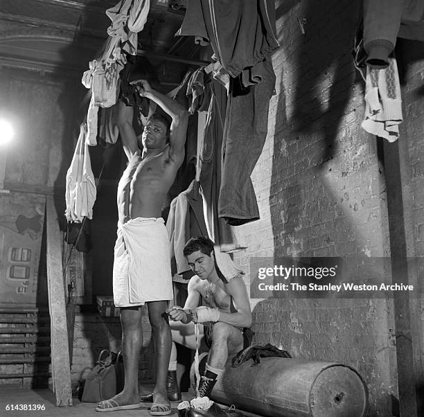 Floyd Patterson hangs up some clothes after a shower at the Gramercy Gym on 14th Street, New York, New York, on January 01, 1954.