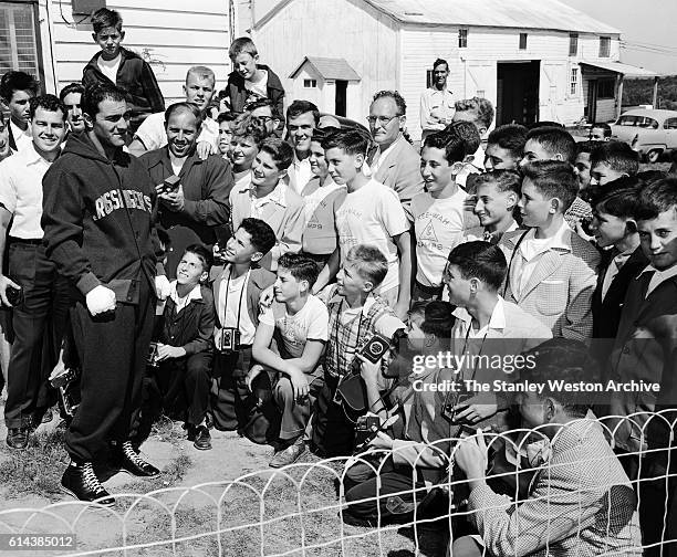 Rocky Marciano takes some time to talk to a group of young fans visiting from camp during his time training for his title defense against Archie...