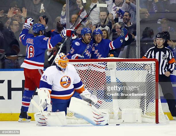 Michael Grabner of the New York Rangers celebrates his first period goal against Jaroslav Halak of the New York Islanders and is joined by Marc Staal...