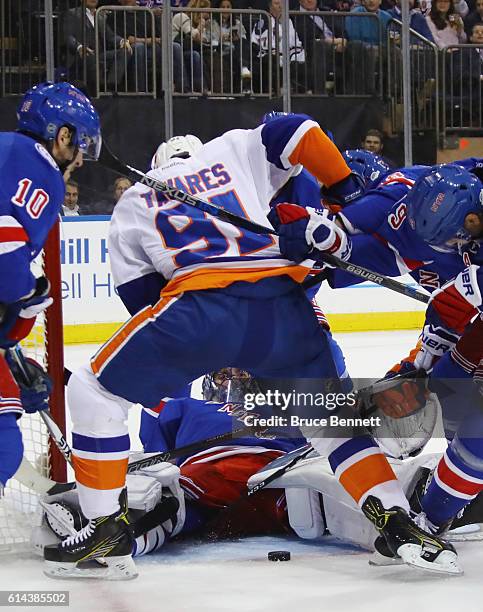 Henrik Lundqvist of the New York Rangers makes the first period save as John Tavares of the New York Islanders looks for the rebound at Madison...