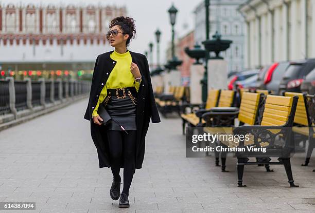 Sara-Joleen Kaveh Moghaddam wearing a yellow Zara sweater, a black leather skirt, Chanel belt, Tigha clutch, Religion wool coat, Dr Martens shoes...