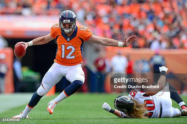 Quarterback Paxton Lynch of the Denver Broncos works for yards after breaking free from a tackle attempt by linebacker A.J. Hawk of the Atlanta...