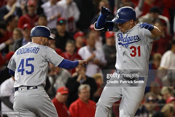 Joc Pederson of the Los Angeles Dodgers celebrates with third base coach Chris Woodward after hitting a solo home run in the seventh inning against...