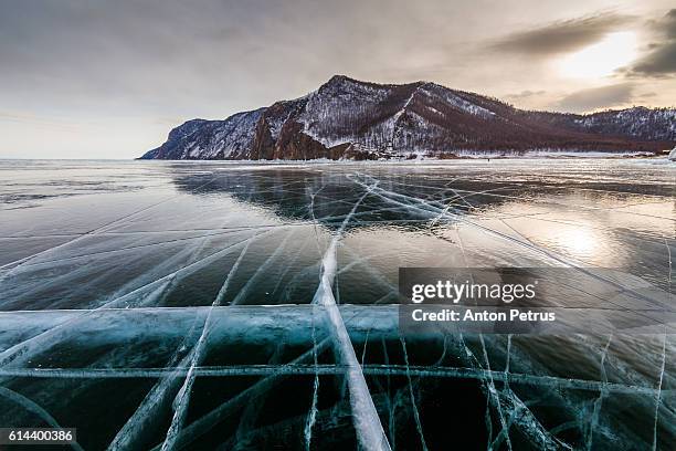 clear ice on lake baikal - frozen lake sunset stock pictures, royalty-free photos & images