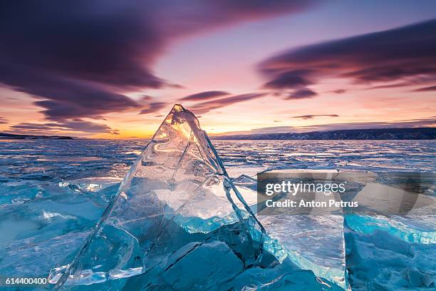 sunset on the ice of lake baikal - eisberg eisgebilde stock-fotos und bilder