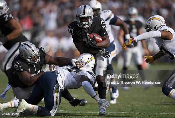 SaQwan Edwards of the Oakland Raiders gets tackled by Jatavis Brown of the San Diego Chargers during an NFL football game at Oakland-Alameda County...