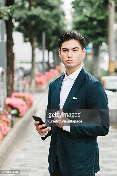 teléfono en manos de un hombre de negocios asiático - solapa papel fotografías e imágenes de stock