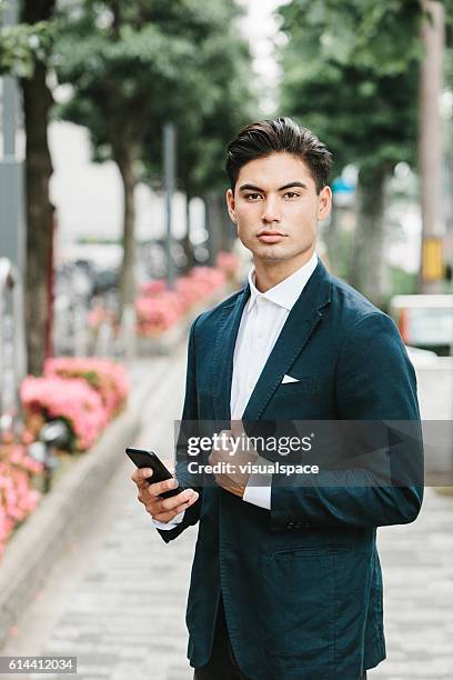 phone in the hands of an asian businessman - lapel suit stock pictures, royalty-free photos & images