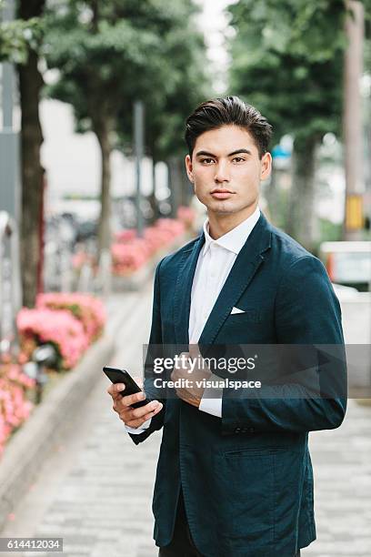 phone in the hands of an asian businessman - lapel 個照片及圖片檔