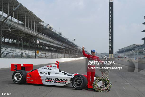 Marlboro Team Penske driver Helio Castroneves poses with his Chevrolet Dallara and the Borg-Warner Trophy at the official trophy presentation on the...