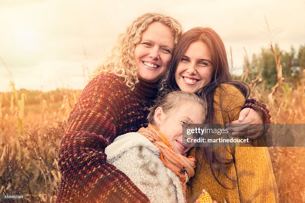 Portrait of teenagers with mother in autumn sunset outdoors.