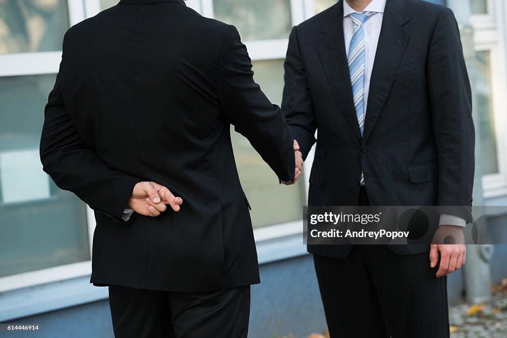 Dishonest Businessman Shaking Hands With Partner