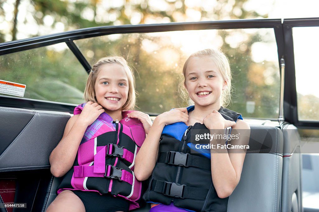 Young female siblings smile while wearing lifejackets